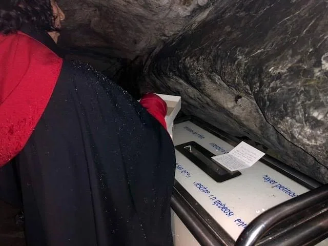 Fotografía ilustrativa de una persona escribiendo una petición en Lourdes; no representa un servicio de entrega ofrecido por esta demostración